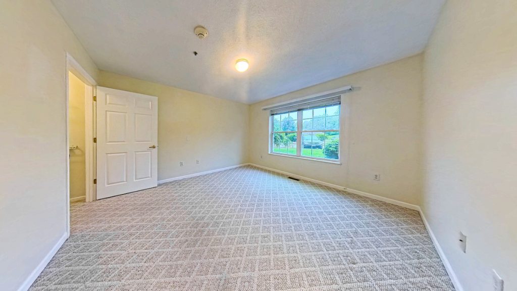 Bedroom with a large window at Emerald Pointe Senior Living in Greenville, Illinois.