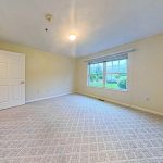 Bedroom with a large window at Emerald Pointe Senior Living in Greenville, Illinois.