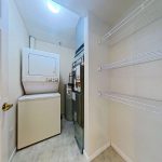 Apartment laundry and storage area with stacked washer and dryer at Emerald Pointe Senior Living in Greenville, Illinois.