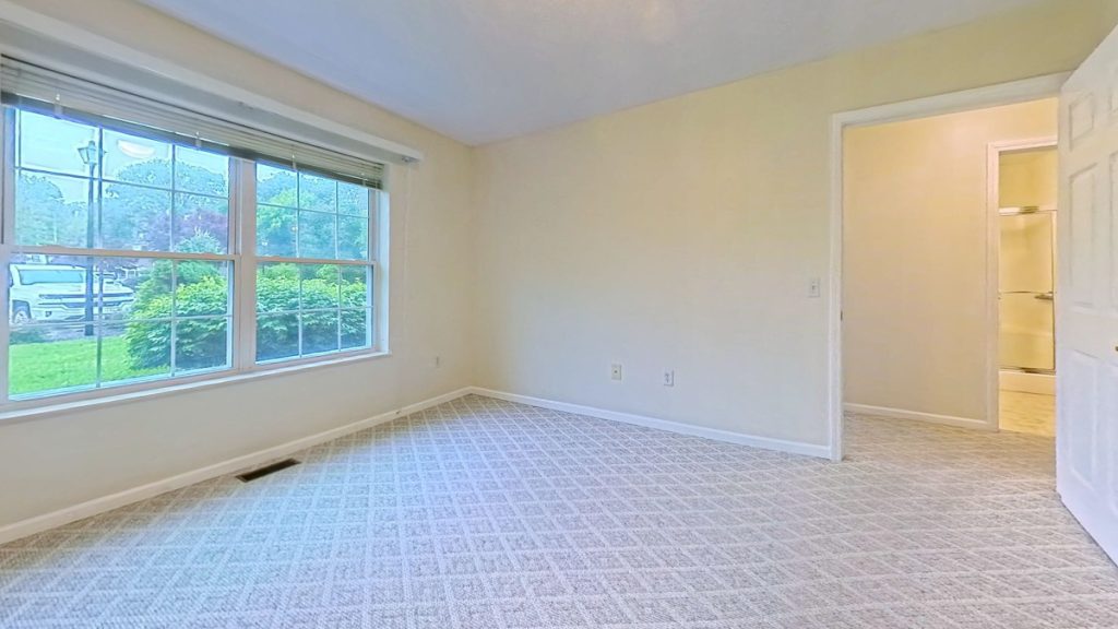 Bedroom with a large window at Emerald Pointe Senior Living in Greenville, Illinois.