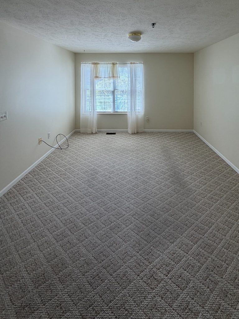 Living room with a window at Emerald Pointe Senior Living in Greenville, Illinois.