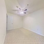 Unfurnished apartment 204 bedroom with carpet and ceiling fan at Emerald Pointe Senior Living in Greenville, Illinois.