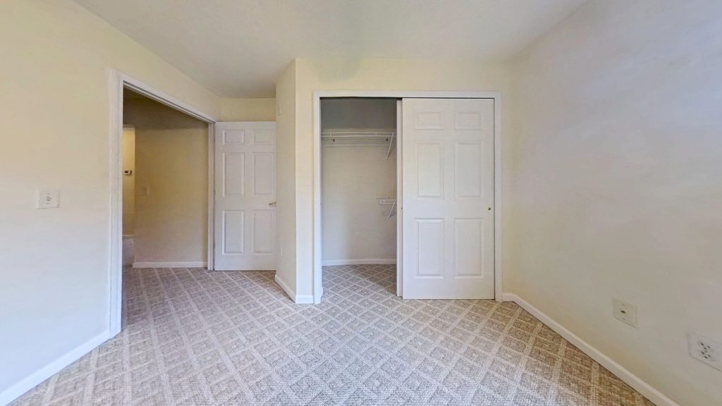 Unfurnished apartment 204 bedroom with carpet and open closet at Emerald Pointe Senior Living in Greenville, Illinois.