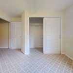 Unfurnished apartment 204 bedroom with carpet and open closet at Emerald Pointe Senior Living in Greenville, Illinois.