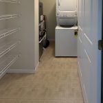Apartment 204 laundry and storage area with stacked washer and dryer at Emerald Pointe Senior Living in Greenville, Illinois.