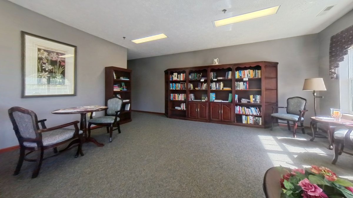 Emerald Pointe library common area with bookshelves and seating